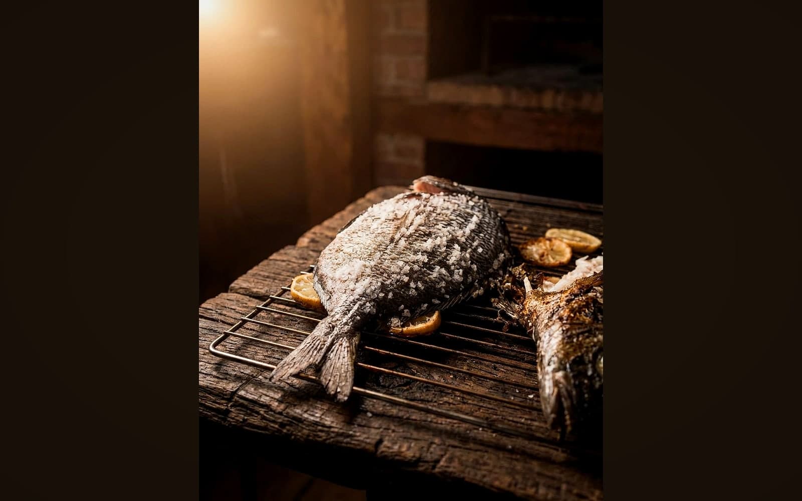 Ganzer Fisch in dicker weißer Salzkruste auf dem Grillrost