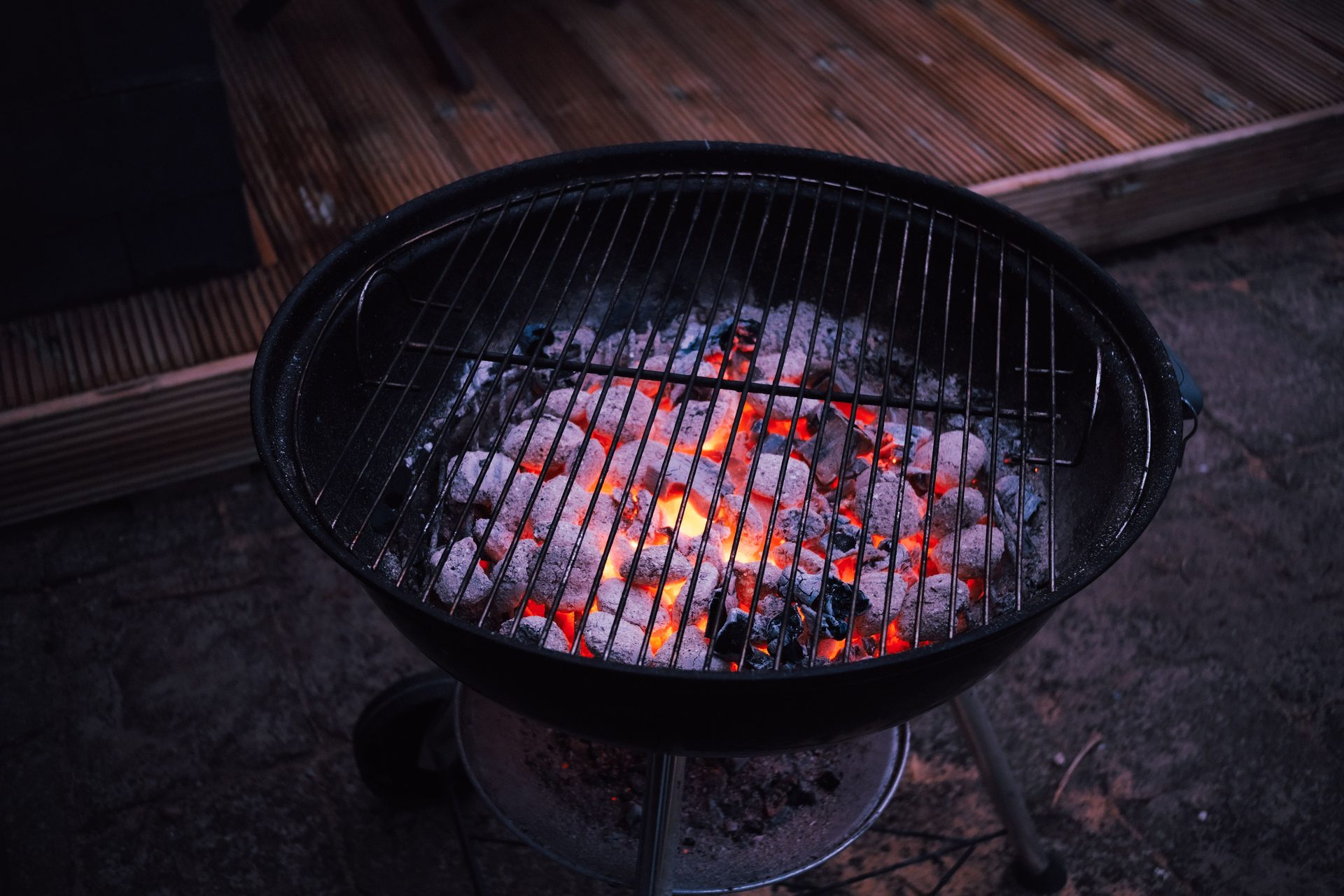 Kugelgrill von oben: Holzkohle mit grauem Ascheüberzug, rote Glut schimmert durch, leerer Rost darüber